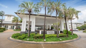 A modern hotel with a covered entrance, palm trees, and a sign reading "manta on salt beach". - Mantra on Salt Beach (Kingscliff)