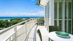 A balcony with a view of the ocean, a table with a bowl, and a chair. - Mantra on Salt Beach (Kingscliff)