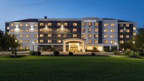 A Courtyard by Marriott hotel with a central entrance, multiple floors, and a well-lit facade. - Courtyard by Marriott Lancaster (Lancaster)