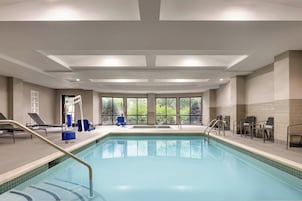 Una piscina techada, sillones reclinables de piscina
