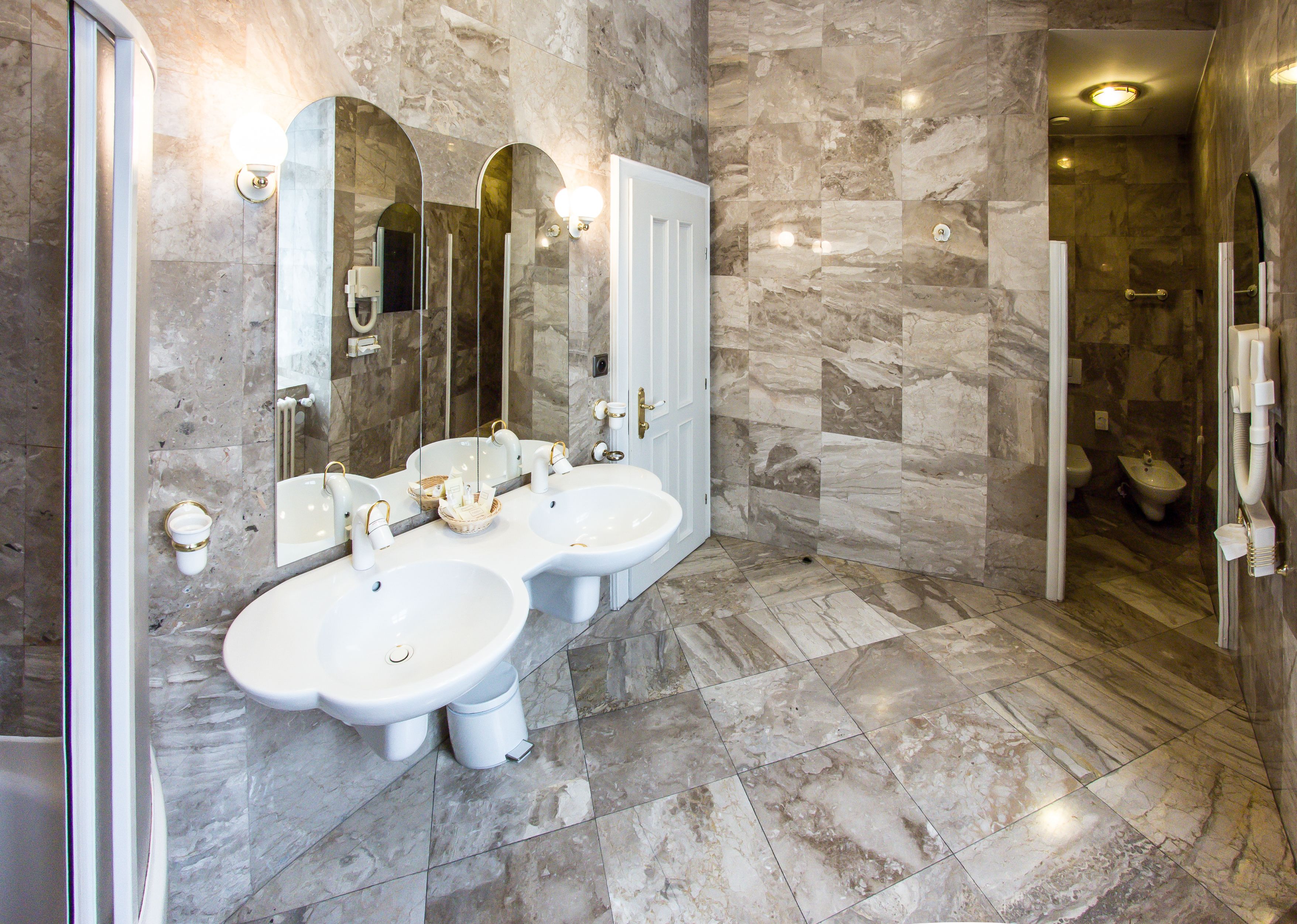 Une salle de bain avec deux lavabos, un miroir et un espace douche.
