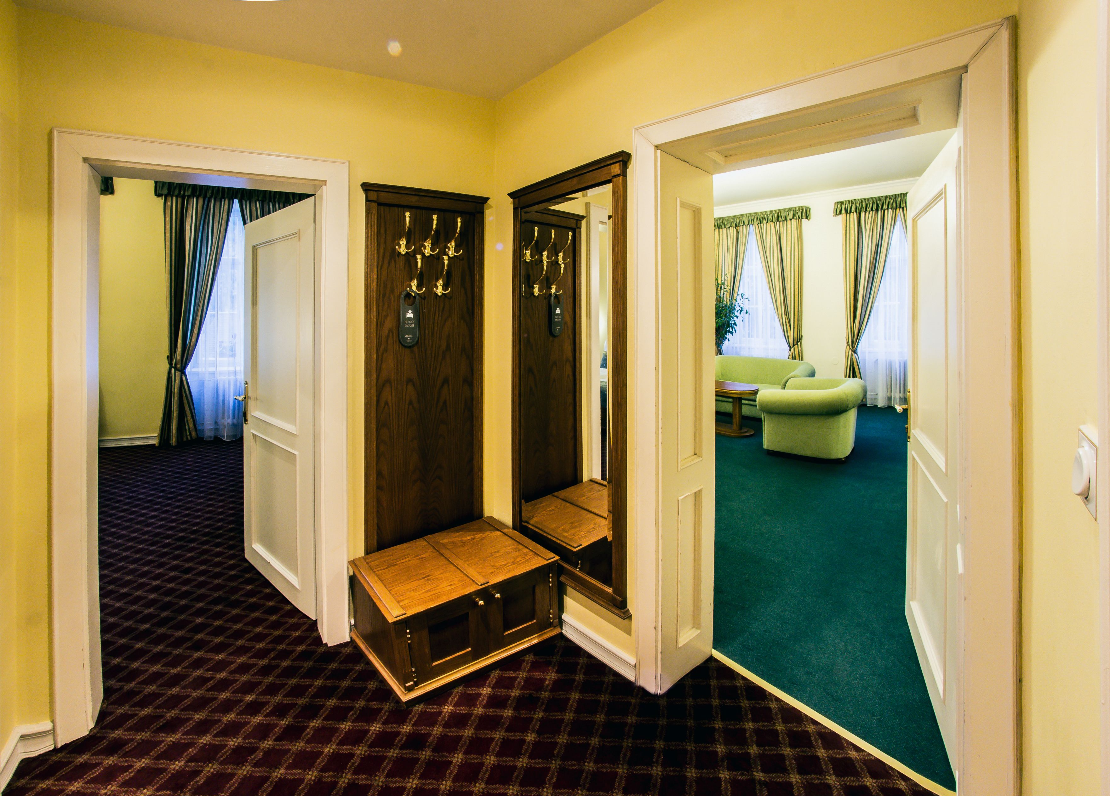 Habitación de hotel con mostrador de recepción, zona de estar con sofá y vistas al pasillo.