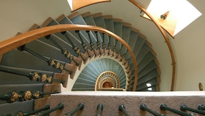 A spiral staircase with a wooden handrail and ornate balusters. - Hotel Dvorak (Cesky Krumlov)