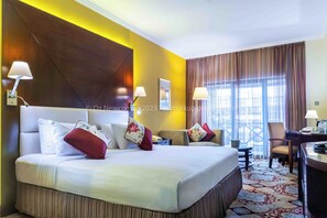 A hotel room with a large bed, two bedside tables, a desk, and a chair. - Coral Dubai Deira Hotel (Dubai)