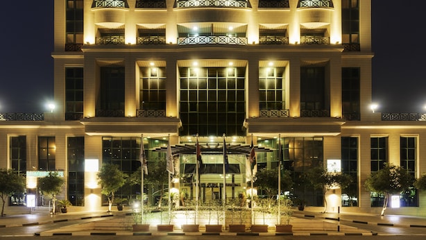Un hotel de varios pisos con balcones y una entrada central.