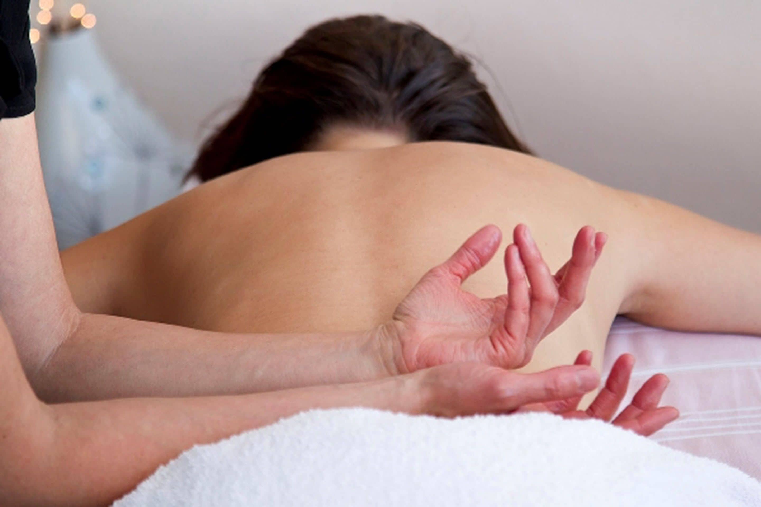 En person modtager en massage af ryggen.