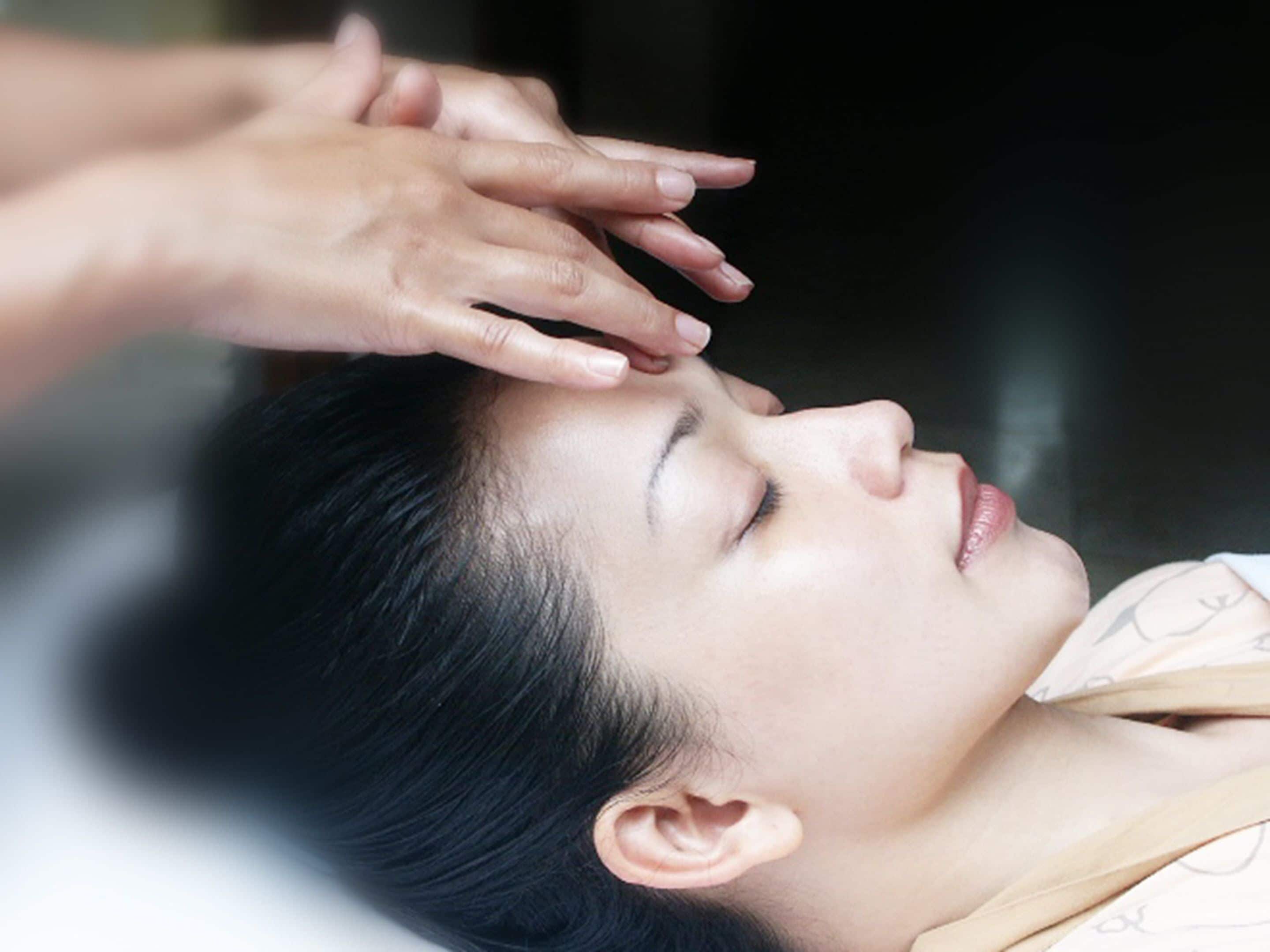 A person lying down with their head resting on a pillow.