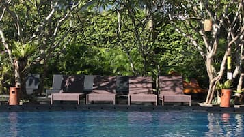 A poolside area with lounge chairs and potted plants.