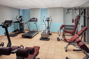 Academia com esteiras, elípticos e equipamentos de musculação.