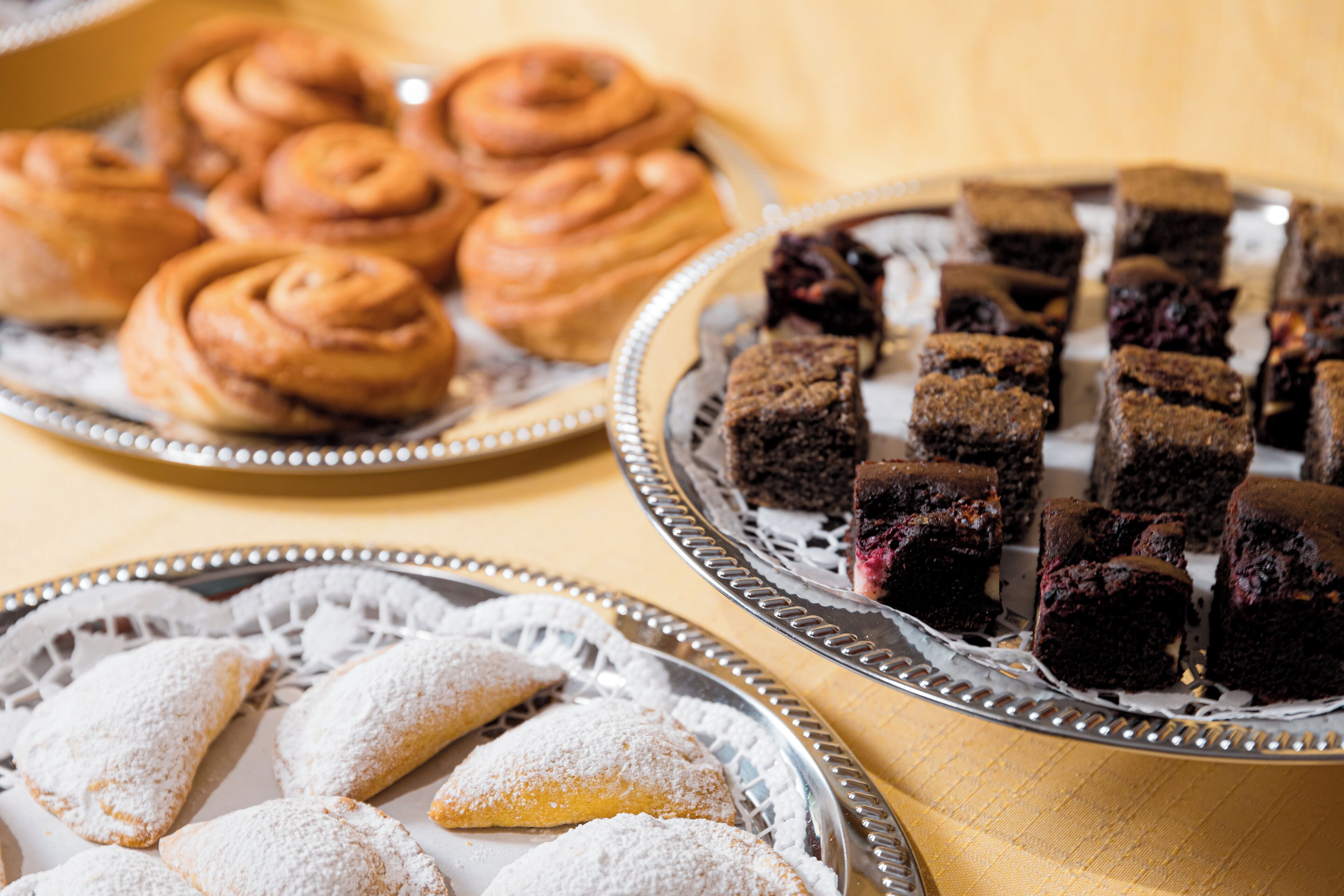 A variety of pastries on silver trays.