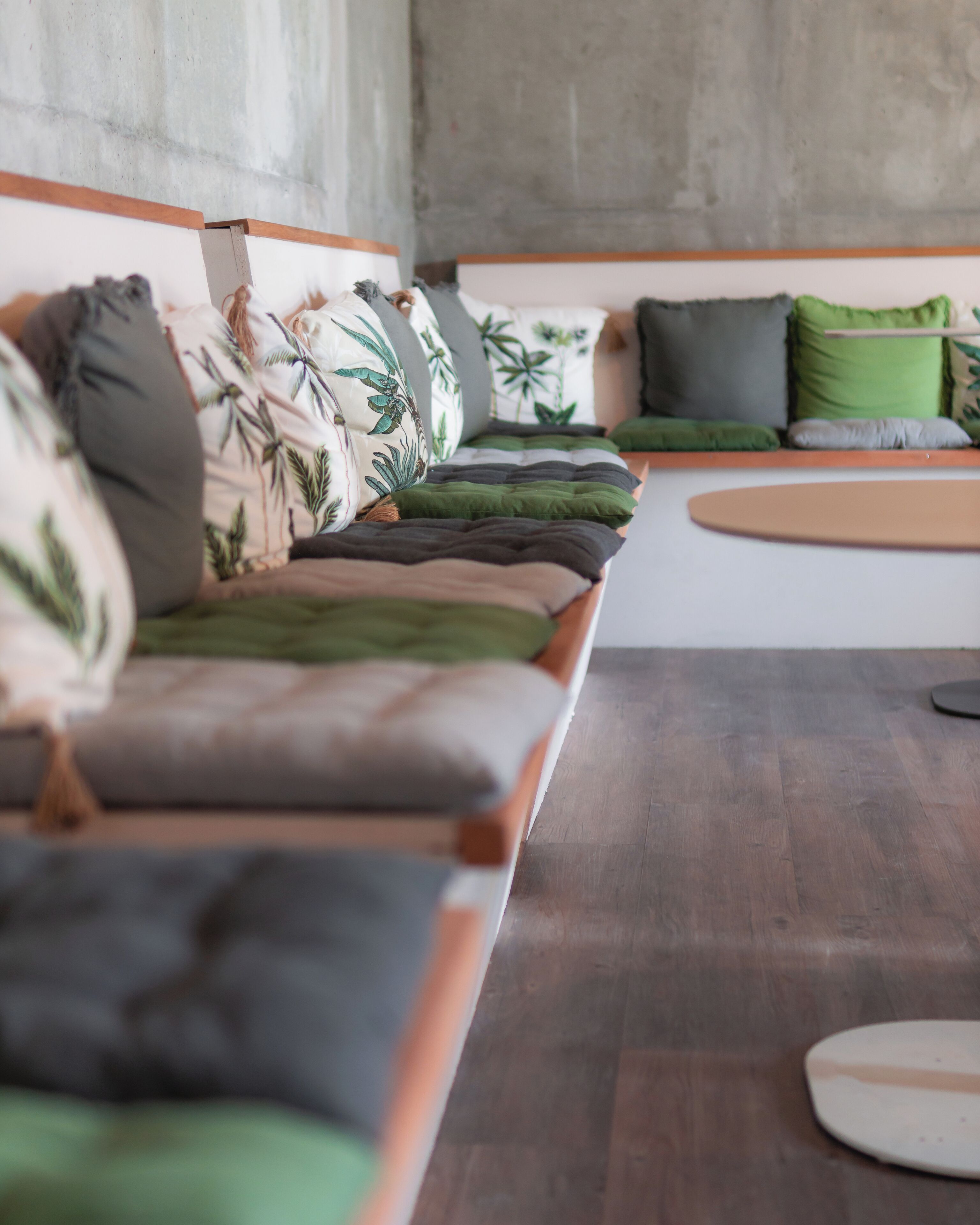 Una sala de estar moderna con un sofá largo, varios cojines y una mesa de centro de madera.