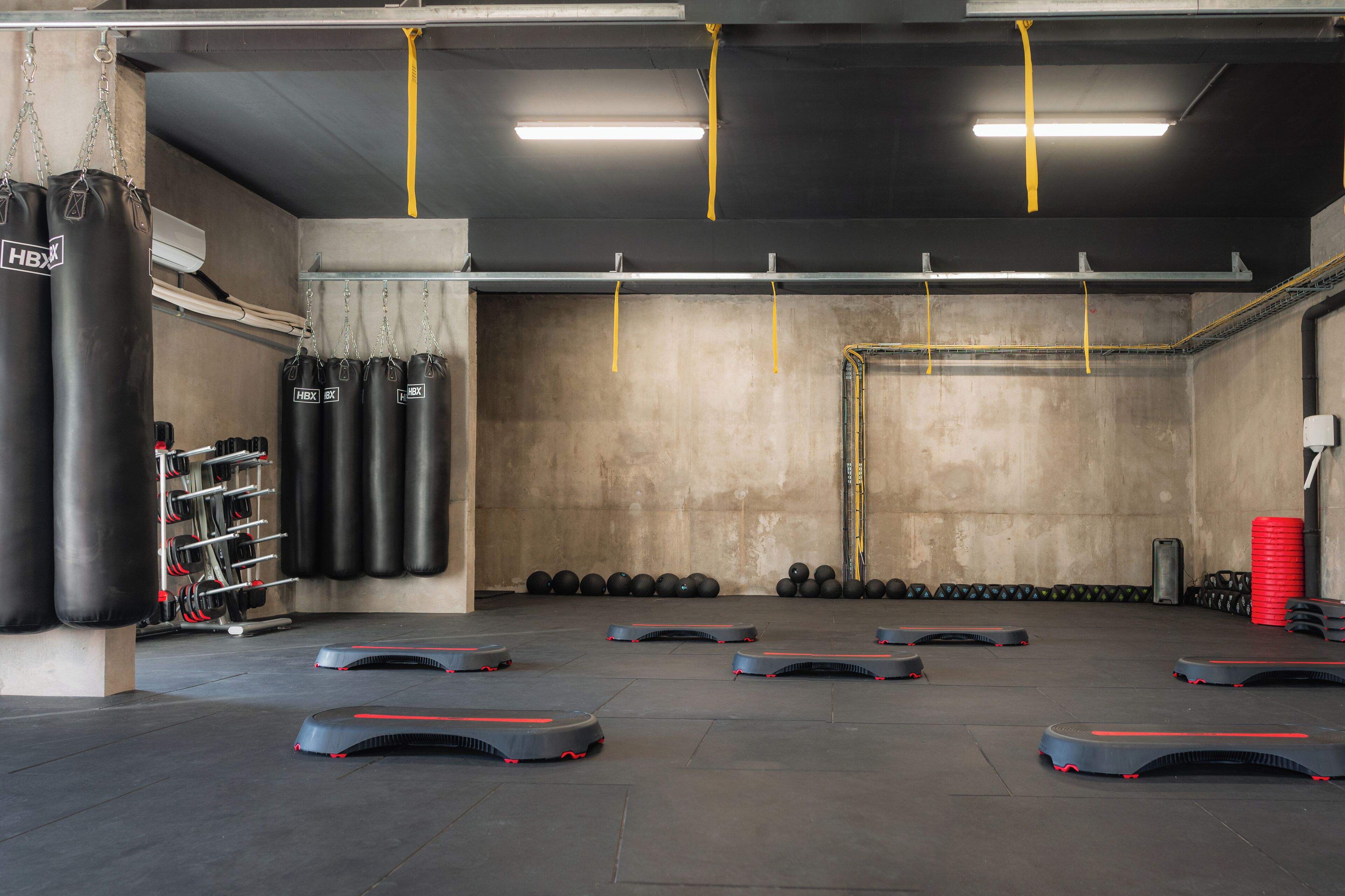 A gym with weightlifting equipment, treadmills, and a punching bag.