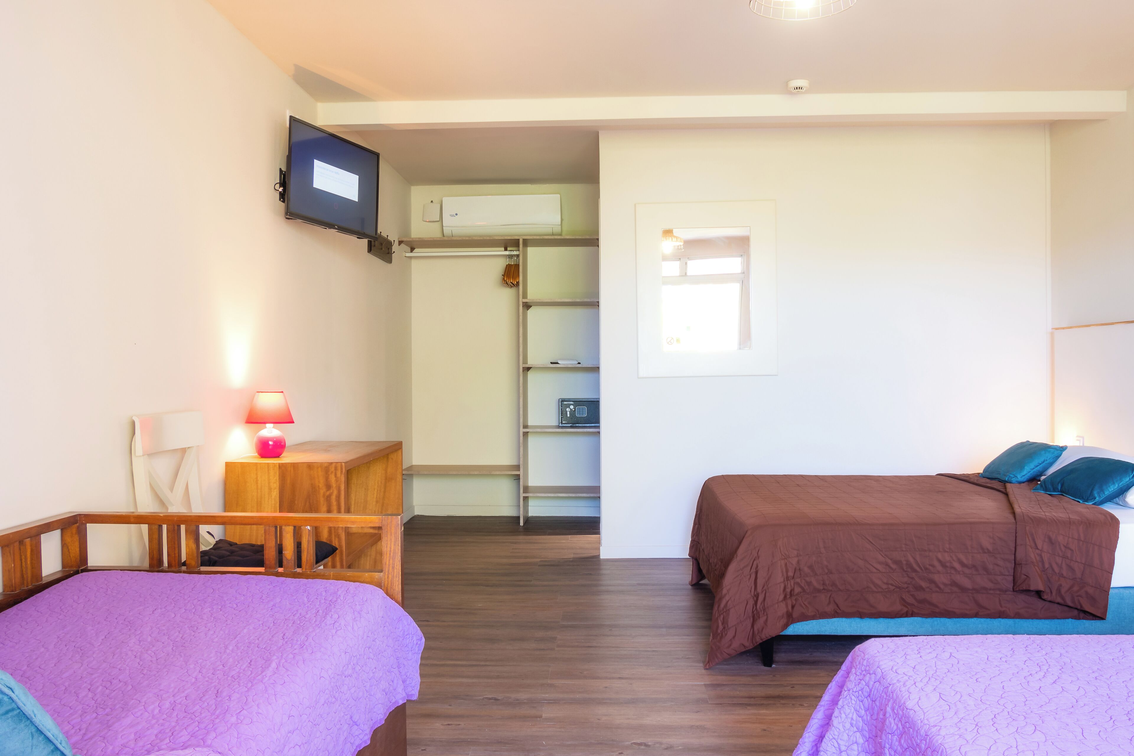 Un dormitorio con dos camas, un escritorio, un televisor y un armario.