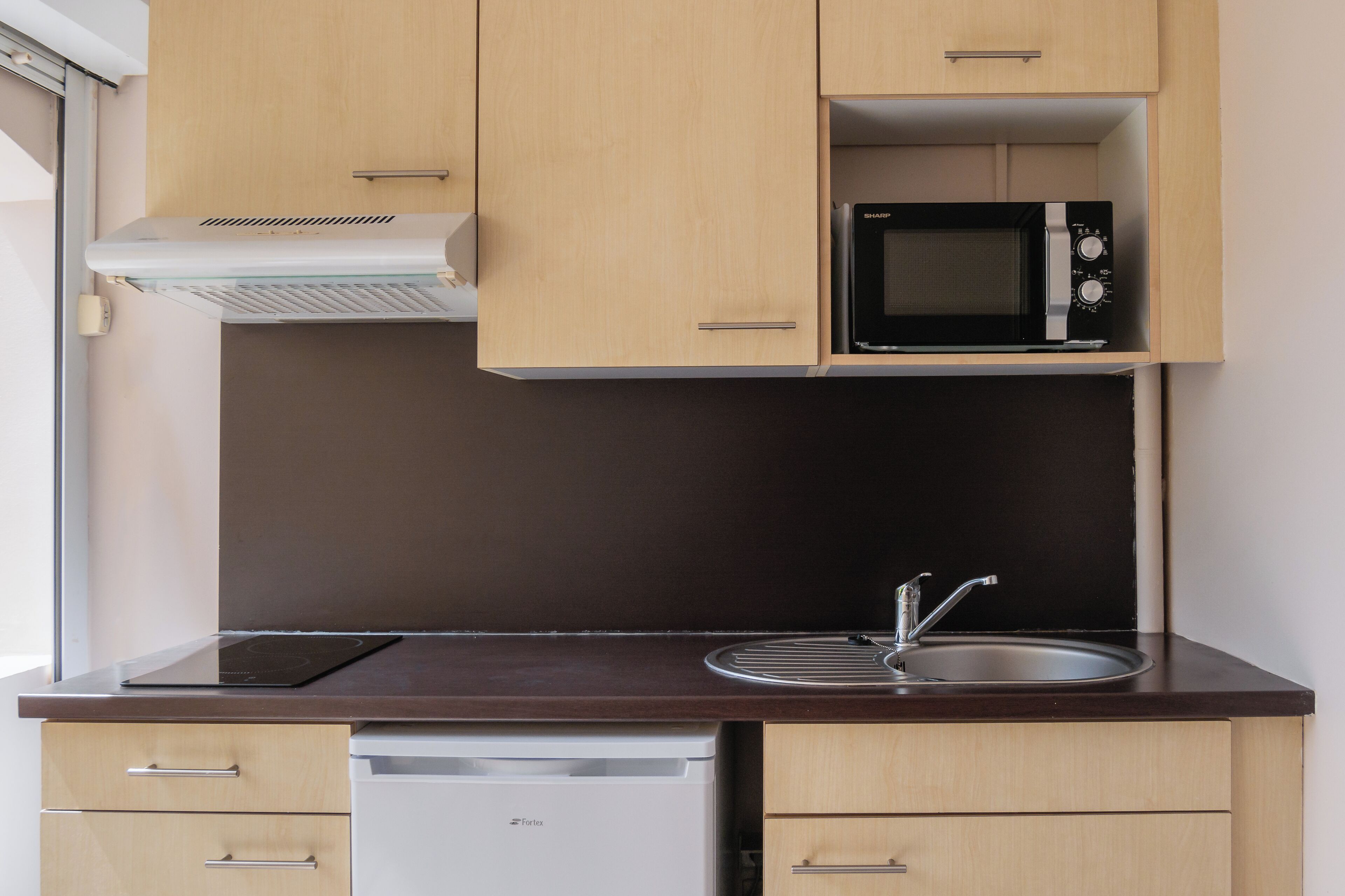 A compact kitchen with a microwave, a dishwasher, and a sink.