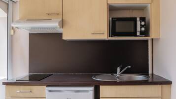 A compact kitchen with a microwave, a dishwasher, and a sink.