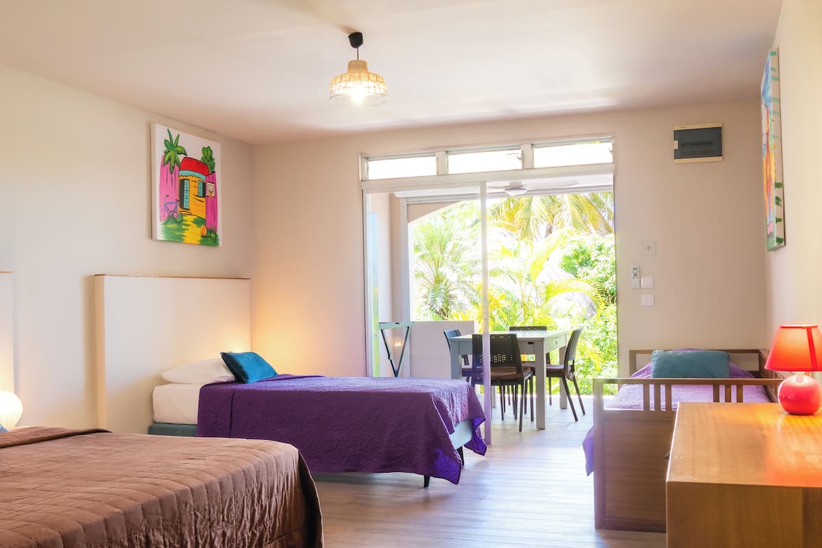 A room with two beds, a desk, and a chair.