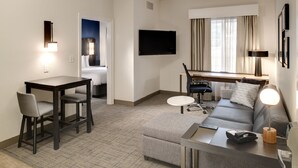 A hotel room with a dining area, a sofa, a TV, and a window with curtains. - Residence Inn by Marriott Columbia Northeast/Fort Jackson Area (Columbia)