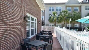 A patio area with outdoor seating and a white picket fence.