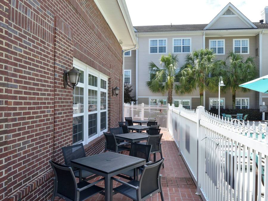 A patio area with outdoor seating and a white picket fence.