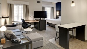 A modern hotel room with a sofa, a desk, a television, a bed, and a small table. - Residence Inn by Marriott Columbia Northeast/Fort Jackson Area (Columbia)
