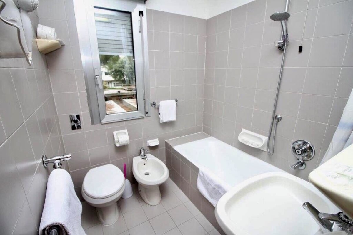 Un baño moderno con inodoro, bidé, bañera y lavabo.