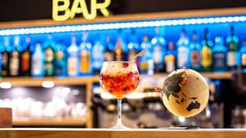 Un bar avec un verre d’une boisson rouge et un globe terrestre posé sur le comptoir.