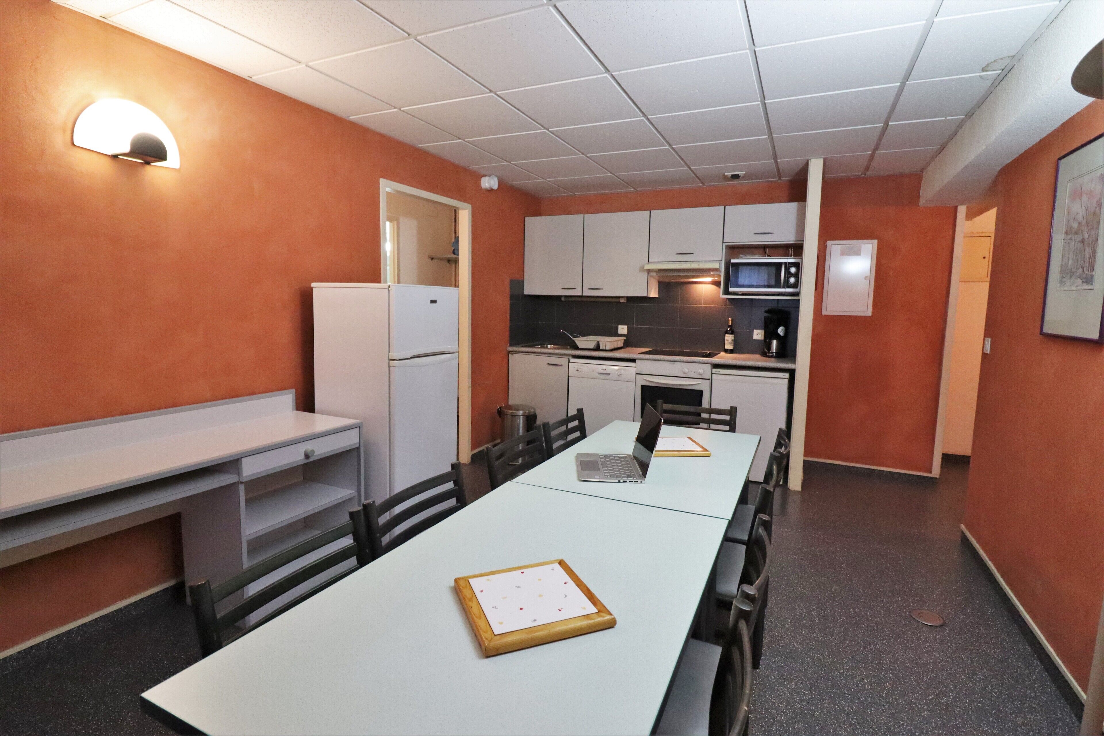 A compact kitchen with white cabinets, a microwave, and a refrigerator.