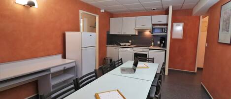 A compact kitchen with white cabinets, a microwave, and a refrigerator.