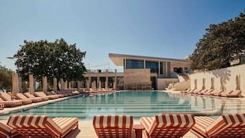 Una piscina al aire libre de temporada, sombrillas