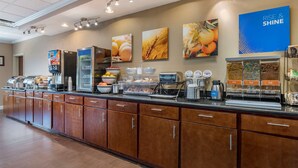 A breakfast bar with a coffee machine, cereal, and fruit bowls. - Comfort Inn & Suites Lawrenceburg (Lawrenceburg)