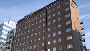 A multi-story hotel with a brick facade, numerous windows, and a visible sign indicating a restaurant on the ground floor. - Hotel Sunroute Asakusa (Tokyo)