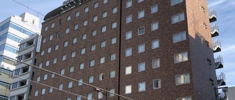 A multi-story hotel with a brick facade, numerous windows, and a visible sign indicating a restaurant on the ground floor.