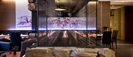 A modern interior with a stone wall and a projection screen displaying a scenic image.