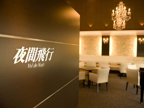 A restaurant interior with a modern design, featuring a chandelier and a seating area with tables and chairs. - Hotel Nikko Himeji (Himeji)