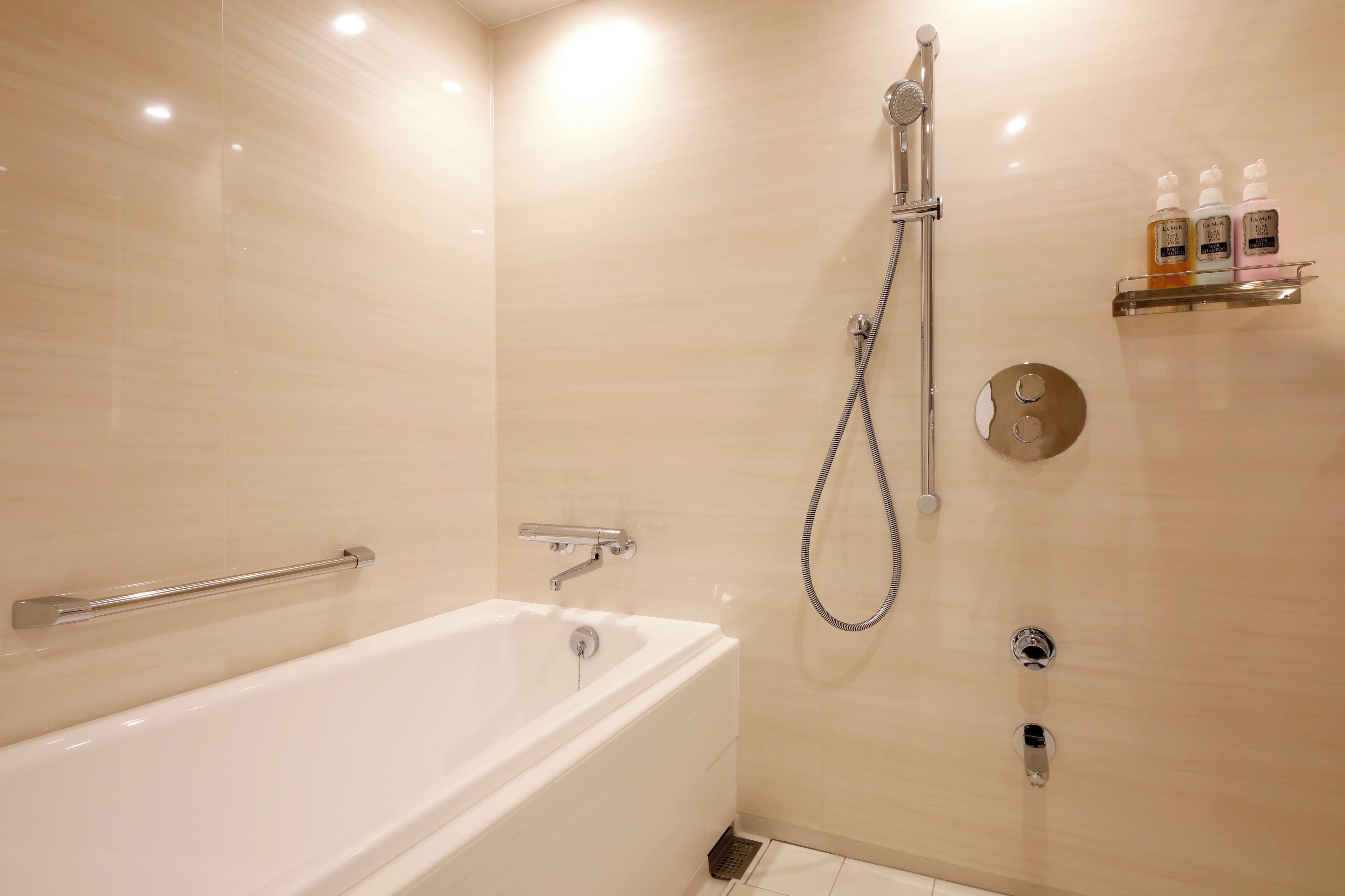 Un baño moderno con bañera, ducha y barra de apoyo.