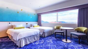A hotel room with two beds, a small table, two chairs, a large window with a view, and a blue carpet with a geometric pattern.