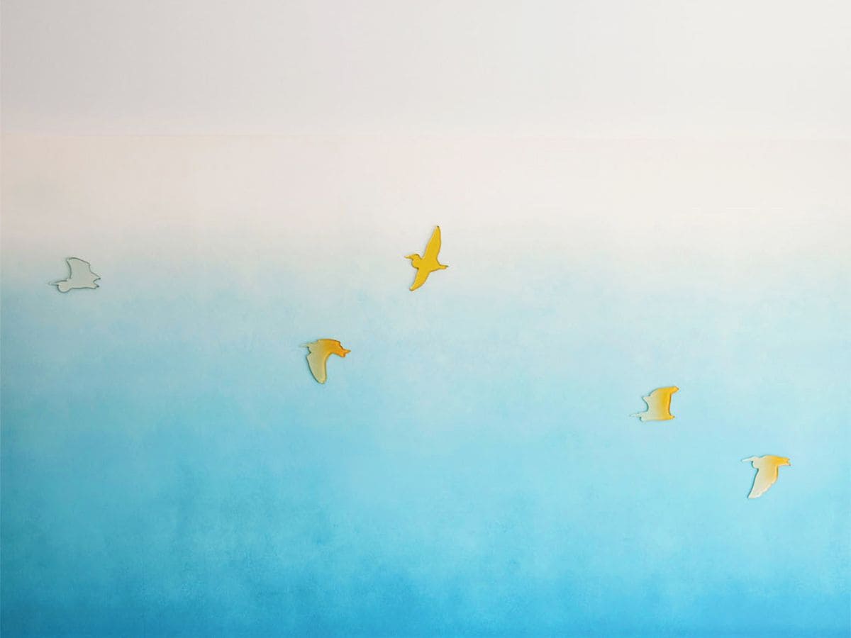 A gradient sky with silhouettes of birds in flight.