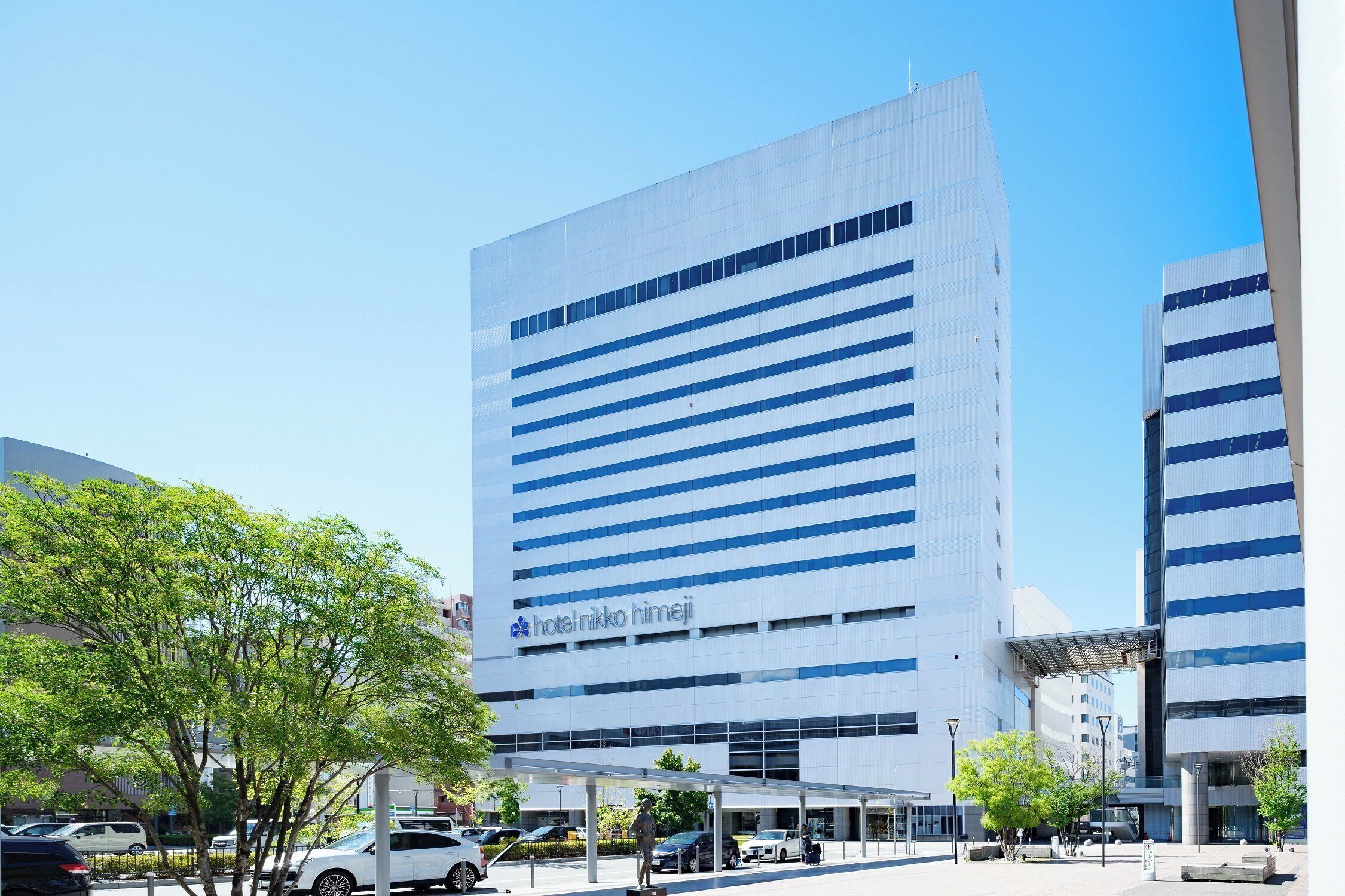 Ein modernes Hotelgebäude mit horizontalen Fenstern und blauem Himmel.