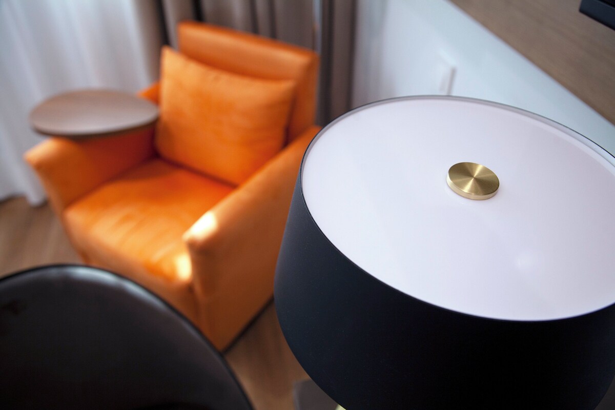 Una sala de estar moderna con un sofá y una lámpara.