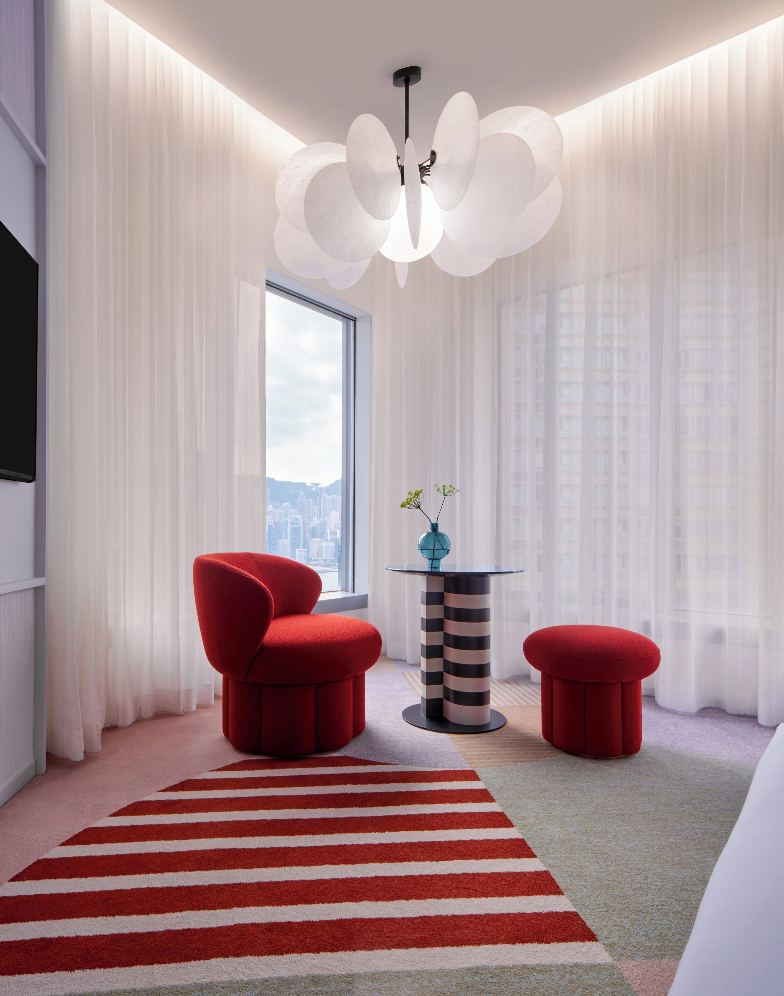 A modern room with a red chair, a small table, and a red ottoman.