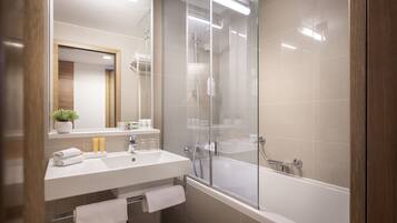 A modern bathroom with a glass-enclosed shower, a white sink, and a bathtub.