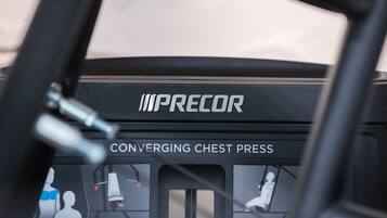 Ein Trainingsgerät mit der Aufschrift "IMPRECOR" und darunter "CONVERGING CHEST PRESS".