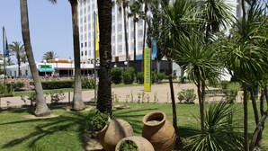 Un espace paysager agrémenté de grands pots en terre cuite, de palmiers et d’un bâtiment sur lequel est apposée une enseigne indiquant « HydroPark ».