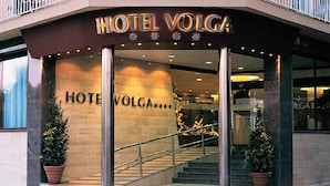 The entrance to HOTEL VOLGA with a prominent sign, a staircase, and potted plants. - KAKTUS Hotel Volga (Calella)
