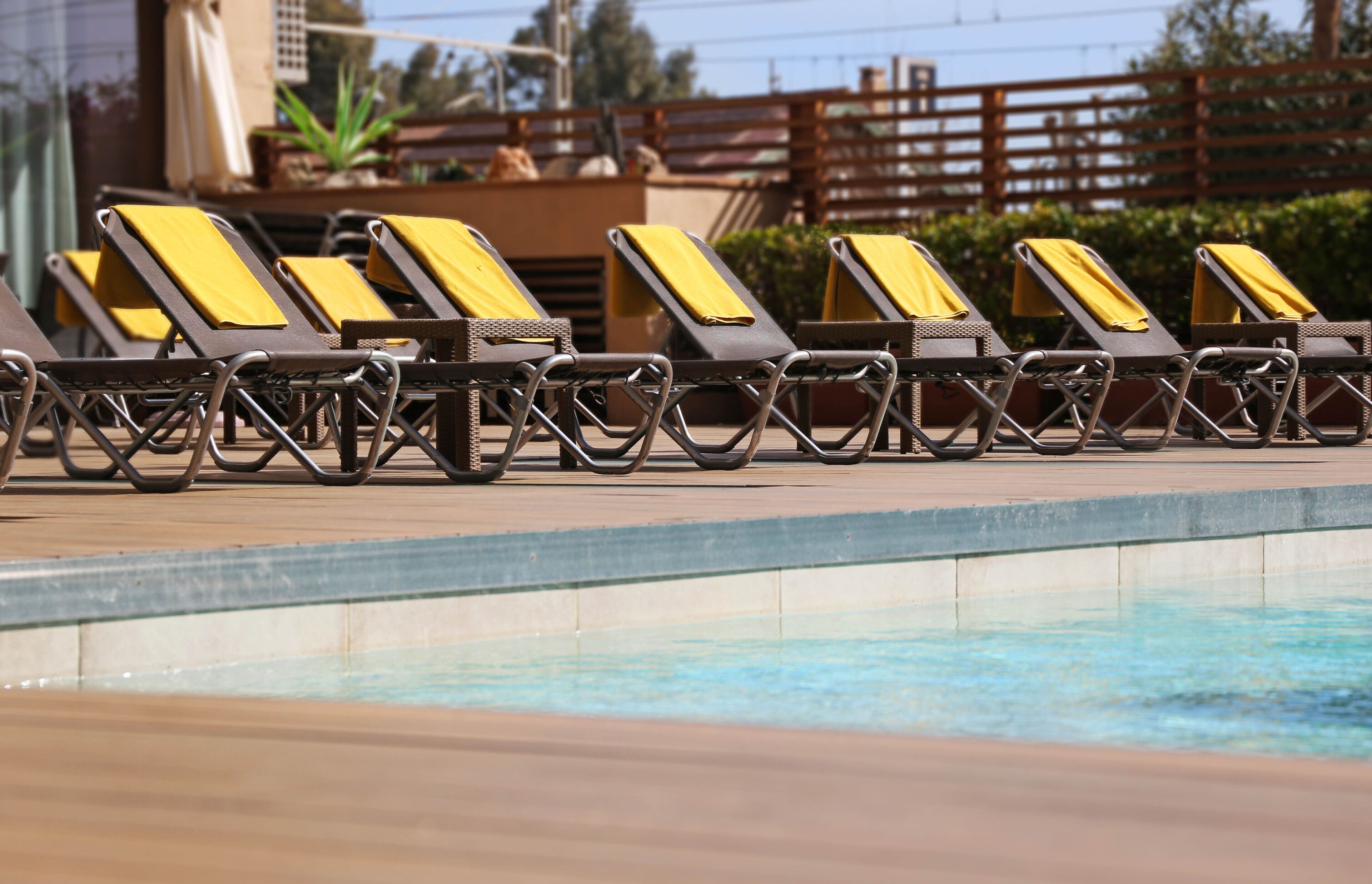 A poolside area with sun loungers and a wooden deck.