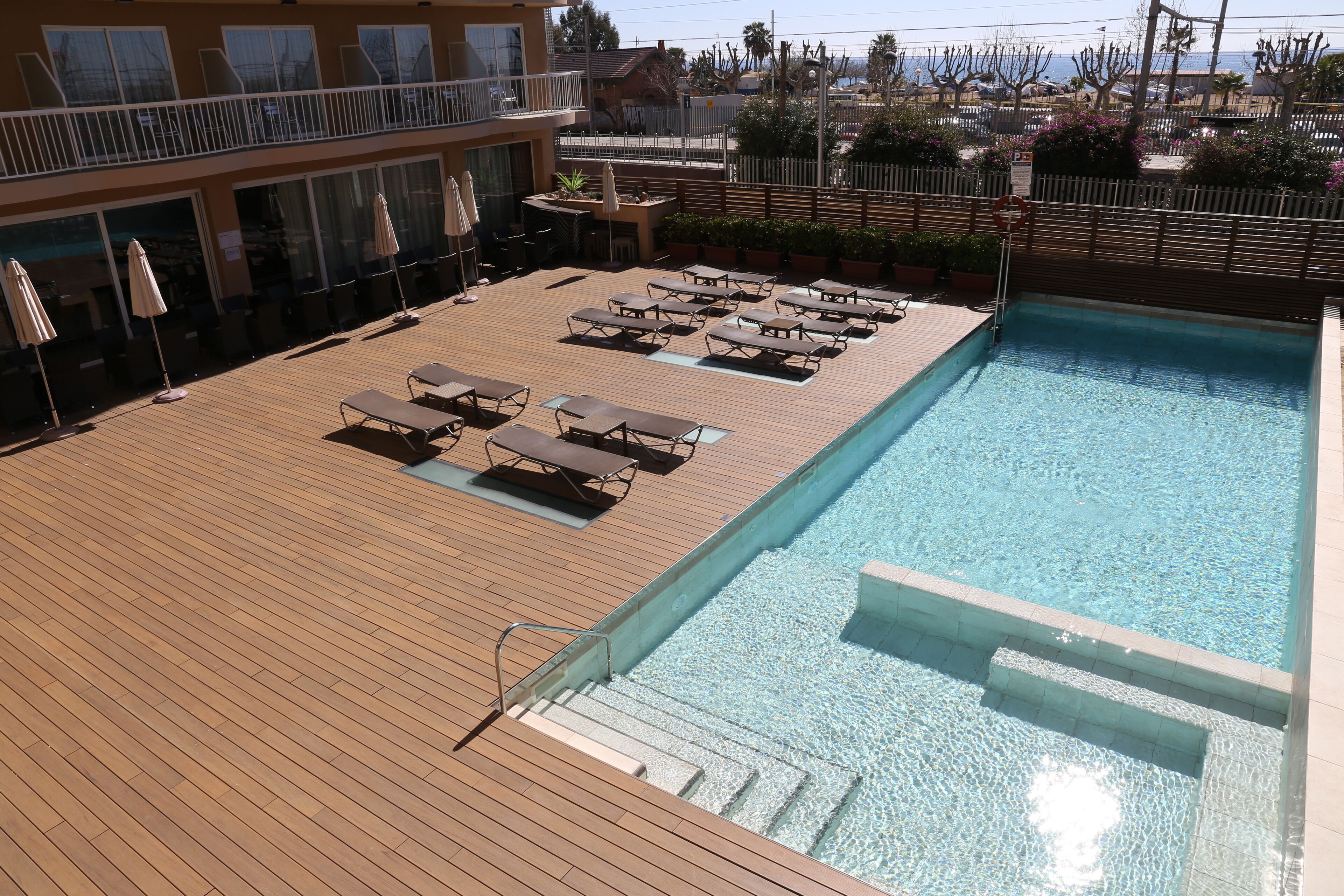 Ein Poolbereich mit Liegestühlen und einer Holzterrasse.