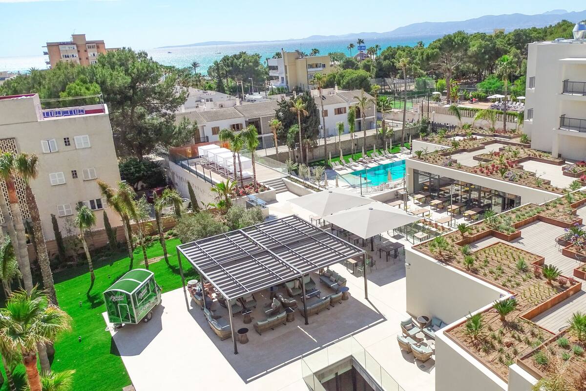 A rooftop pool area with lounge seating and a view of the sea.