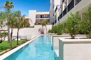A swimming pool with a clear blue water, surrounded by greenery and modern buildings. - Paradiso Garden Hotel (Palma de Mallorca)