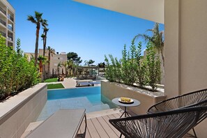 A pool area with lounge chairs and a table, surrounded by greenery and buildings. - Paradiso Garden Hotel (Palma de Mallorca)