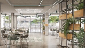 Un restaurant moderne avec de hauts plafonds, des conduits apparents et un mélange de mobilier en métal et en bois.